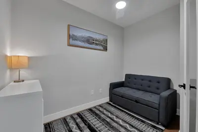 a black couch in a room with a picture on the wall at Harrison Hot Springs Lakeside in Harrison Hot Springs
