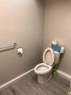 a bathroom with a toilet with the seat up at Comfort cottage guest home near subway station, bus and downtown in Vancouver
