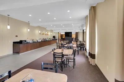 a restaurant with tables and chairs and a counter at Duvernay Inn & Suites in Fox Creek