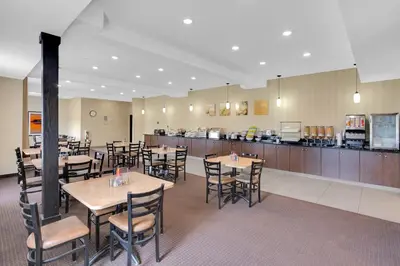 a restaurant with tables and chairs and a bar at Duvernay Inn & Suites in Fox Creek