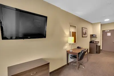 a hotel room with a large flat screen tv on the wall at Duvernay Inn & Suites in Fox Creek