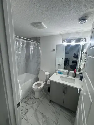 a bathroom with a toilet and a tub and a sink at The Nesting Cove in Airdrie
