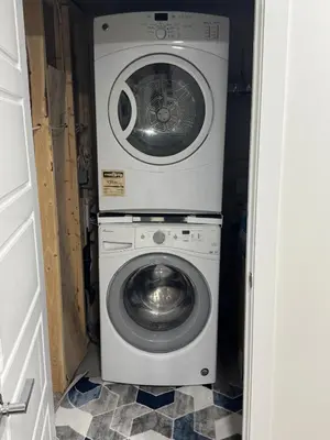 a washing machine and a washer in a small room at The Nesting Cove in Airdrie