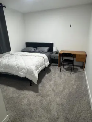 a bedroom with a bed and a desk and a table at The Nesting Cove in Airdrie