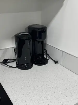a black coffee maker sitting on top of a counter at The Nesting Cove in Airdrie