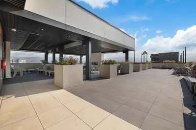 an outdoor patio with tables and chairs on a building at Central Kelowna TOP FLOOR rooftop patio in Kelowna