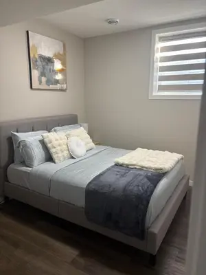 a bedroom with a bed with pillows and a window at Relax in Comfort, AC, YYC, CrossIron Mills, Banff in Calgary
