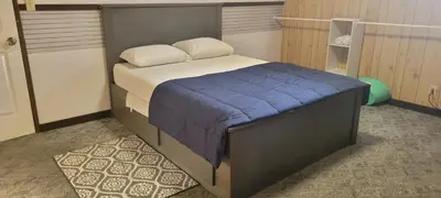 a bedroom with a bed with a blue blanket at WhiteCourt in Abbotsford