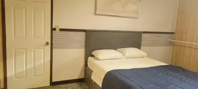 a small bedroom with a bed and a door at WhiteCourt in Abbotsford