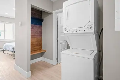 a white laundry room with a washer and dryer at Boutique-Style Studio Unit in Edmonton