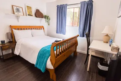a bedroom with a bed and a desk and a window at Bright & Spacious House Near UBC in Vancouver