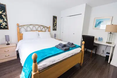 a bedroom with a bed with a desk and a chair at Bright & Spacious House Near UBC in Vancouver