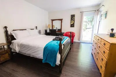 a bedroom with a bed and a dresser and a window at Bright & Spacious House Near UBC in Vancouver
