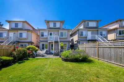 a large house with a fence and a yard at 2 Bds suite beautiful Yard near PNE in Vancouver