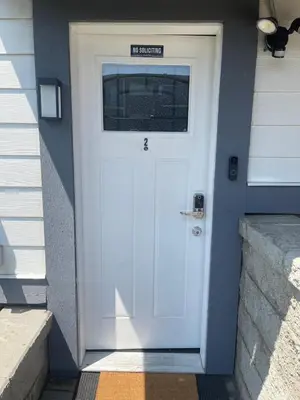 a white door on a house with a sign on it at Top choice 2-Bed 1-Bath Garden Suite in New Westminster