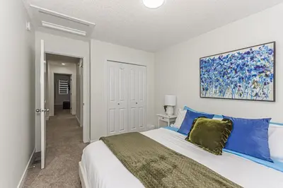 a bedroom with a large bed with blue pillows at Escape in Style, River Cree, Netflix, Near WEM in Edmonton