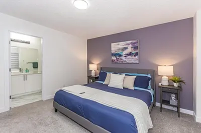 a bedroom with a bed with a blue wall at Escape in Style, River Cree, Netflix, Near WEM in Edmonton