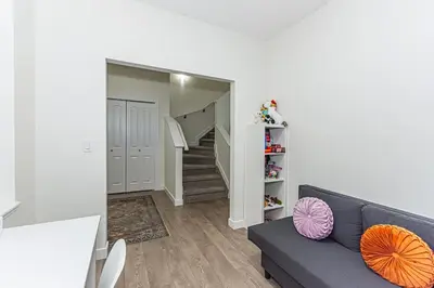 a living room with a blue couch and a staircase at Escape in Style, River Cree, Netflix, Near WEM in Edmonton