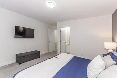 a bedroom with a large bed and a flat screen tv at Escape in Style, River Cree, Netflix, Near WEM in Edmonton