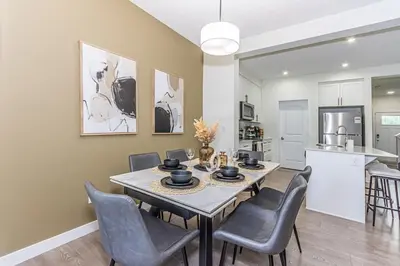 a kitchen and dining room with a table and chairs at Escape in Style, River Cree, Netflix, Near WEM in Edmonton