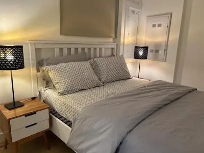 a bedroom with a bed and two lamps on tables at Modern 2bd suite near Langley Events Centre in Langley
