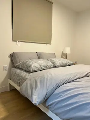 a bedroom with a bed and a projection screen on the wall at Modern 2bd suite near Langley Events Centre in Langley