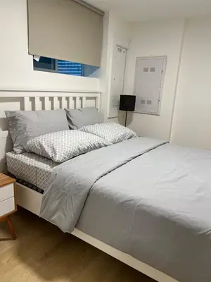 a white bedroom with a bed and a night stand at Modern 2bd suite near Langley Events Centre in Langley