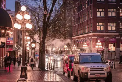 a busy city street at night with cars parked at Modern Downtown Stay! in Vancouver