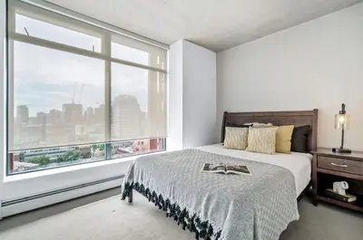 a bedroom with a bed and a large window at Modern Downtown Stay! in Vancouver