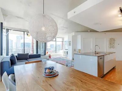 a kitchen and living room with a table and a couch at Modern Downtown Stay! in Vancouver
