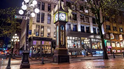 a clock tower on a city street at night at Modern Downtown Stay! in Vancouver