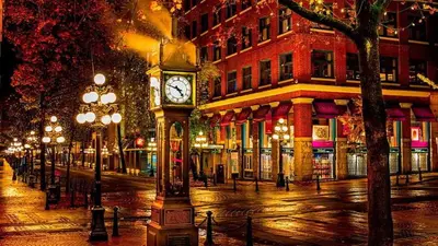a clock tower on a city street at night at Modern Downtown Stay! in Vancouver