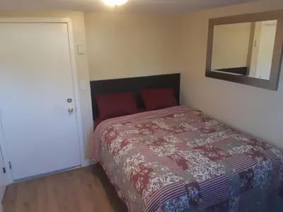 a bedroom with a bed and a mirror on the wall at Gordon Head Bed & Breakfast 2 Bathroom 4TV 5 Beds, Private Yard, Kids Gym & Games, Breakfast, WorkStn, Laundry, Kitchen in Victoria