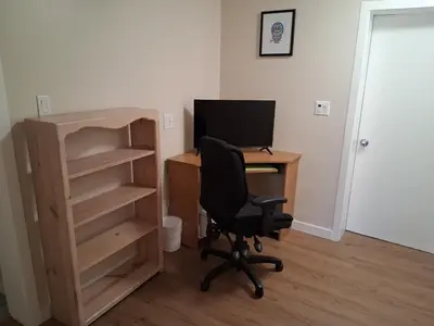 an office with a desk with a computer and a chair at Gordon Head Bed & Breakfast 2 Bathroom 4TV 5 Beds, Private Yard, Kids Gym & Games, Breakfast, WorkStn, Laundry, Kitchen in Victoria
