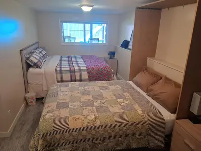 a small bedroom with two beds in it at Gordon Head Bed & Breakfast 2 Bathroom 4TV 5 Beds, Private Yard, Kids Gym & Games, Breakfast, WorkStn, Laundry, Kitchen in Victoria