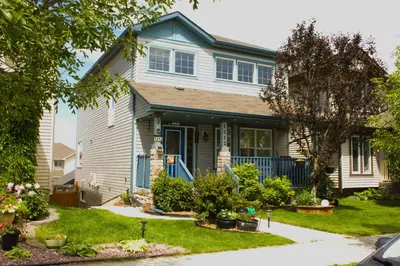 a house with a blue door and a yard at Entire Walkout Basement Suite 2 BDRM King & Queen Patio Prvt Entrance in Edmonton