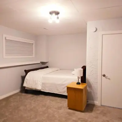 a bedroom with a bed and a table with a lamp at Dream house in Edmonton