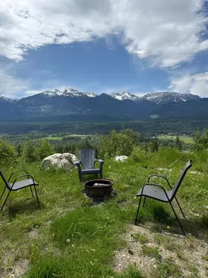 two chairs and a fire pit with mountains in the background at Uncle Bills Cabin Entire home 6 min south of town in Golden