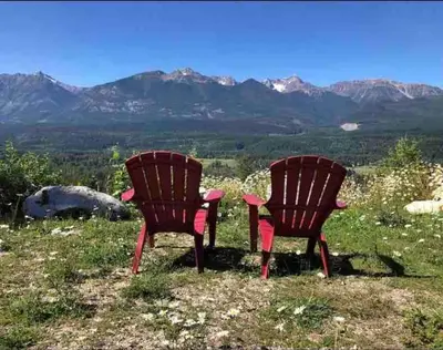 two chairs sitting on a hill with mountains in the background at Uncle Bills Cabin Entire home 6 min south of town in Golden
