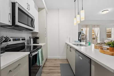 a kitchen with white countertops and a microwave at Full Townhouse Cozy Guest Favorite Garage Parking Aspen Neighbourhood in Calgary