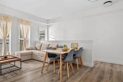 a living room with a table and chairs and a couch at Full Townhouse Cozy Guest Favorite Garage Parking Aspen Neighbourhood in Calgary