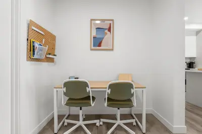 a table with two chairs in a room at Full Townhouse Cozy Guest Favorite Garage Parking Aspen Neighbourhood in Calgary