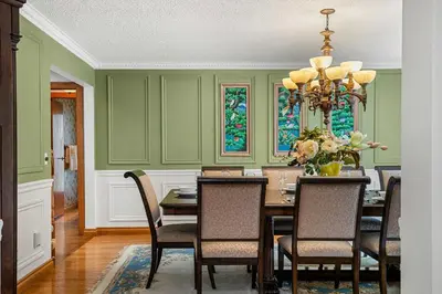 a dining room with green walls and a table with chairs at Freele Escape Secluded Nature Haven Sleeps 17 in Priddis