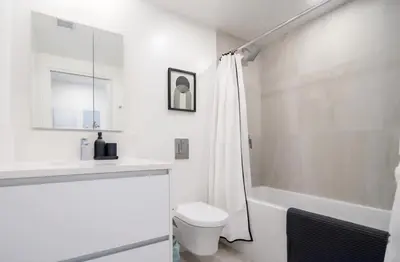 a white bathroom with a toilet and a sink at Peaceful City Stay, Calm Vibes in a Cozy in Vancouver