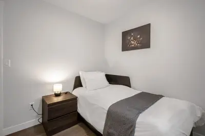 a bedroom with a bed and a night stand with a lamp at New 2BD Suite Near Events Center in Langley