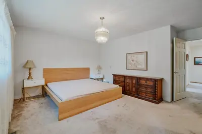 a bedroom with a bed and a dresser and a lamp at The Coastal Garden Retreat in Delta