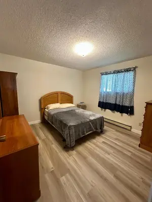 a bedroom with a bed and a wooden floor at Beautiful home near City centre! in Kitimat
