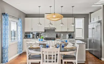 a kitchen with a table and chairs and a kitchen with a refrigerator at Luxe & Lake 6BR Getaway Hot Tub Near the Lake in Sylvan Lake