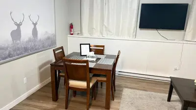 a dining room with a table with chairs and a laptop at Supinder's Rentals in Golden