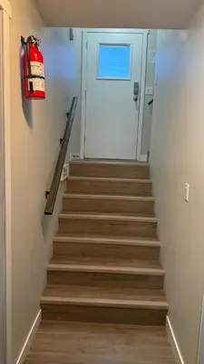a stairway leading to a door with a fire extinguisher at Supinder's Rentals in Golden
